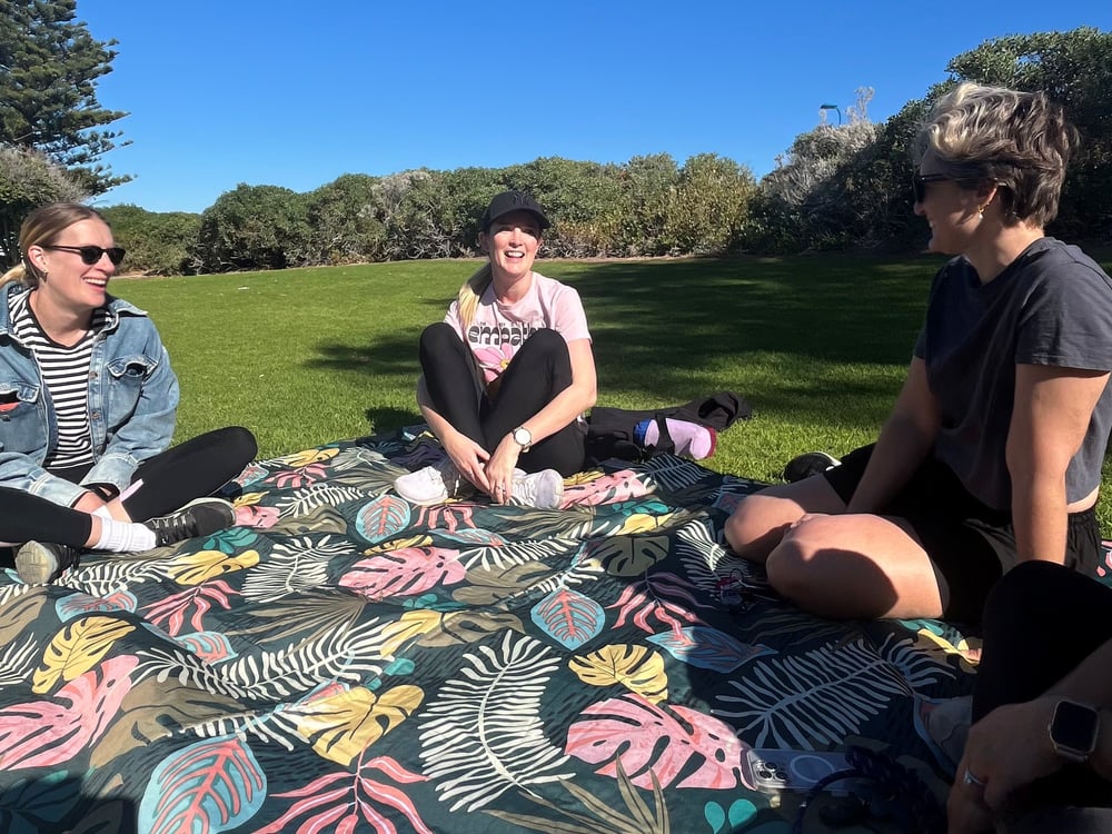 Three Heart First Founders members chatting on a picnic blanket